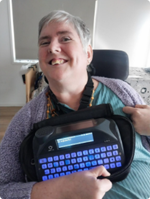 Nichole smiling and holding her communication device
